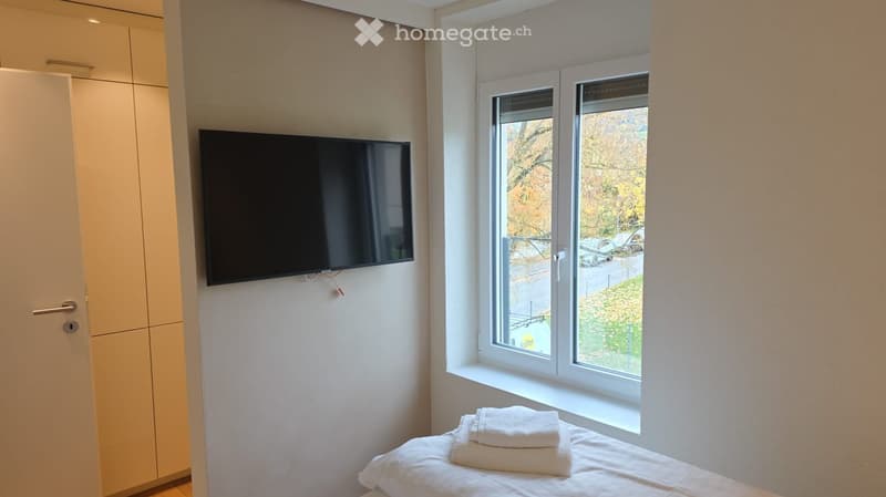small room with a bed, a TV, and a window with a view