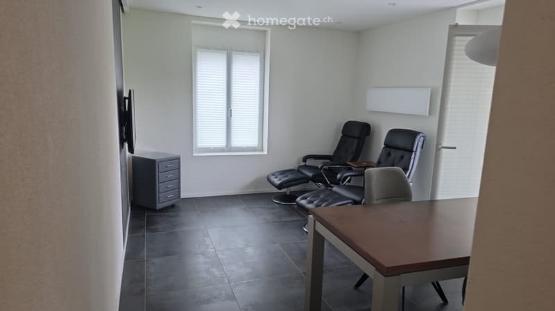 small room with a table, chairs, a TV, and a cabinet