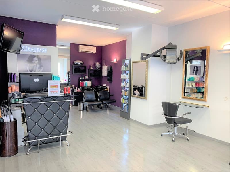 modern salon with black reception desk, black chairs, white cabinets, mirrors, purple walls, lights