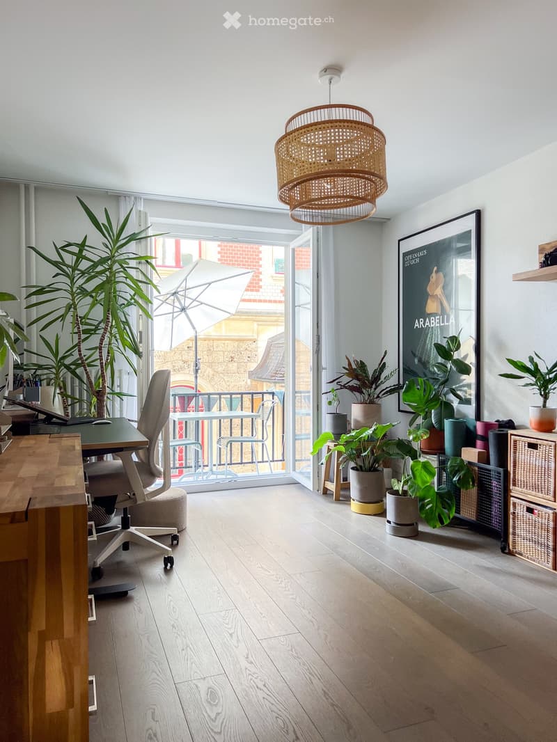 office room with desk, office chair, plants, balcony, large windows, picture frame