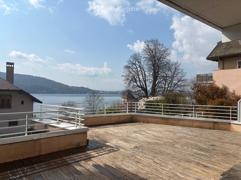 wooden deck, white railings, lake view, mountains in the distance