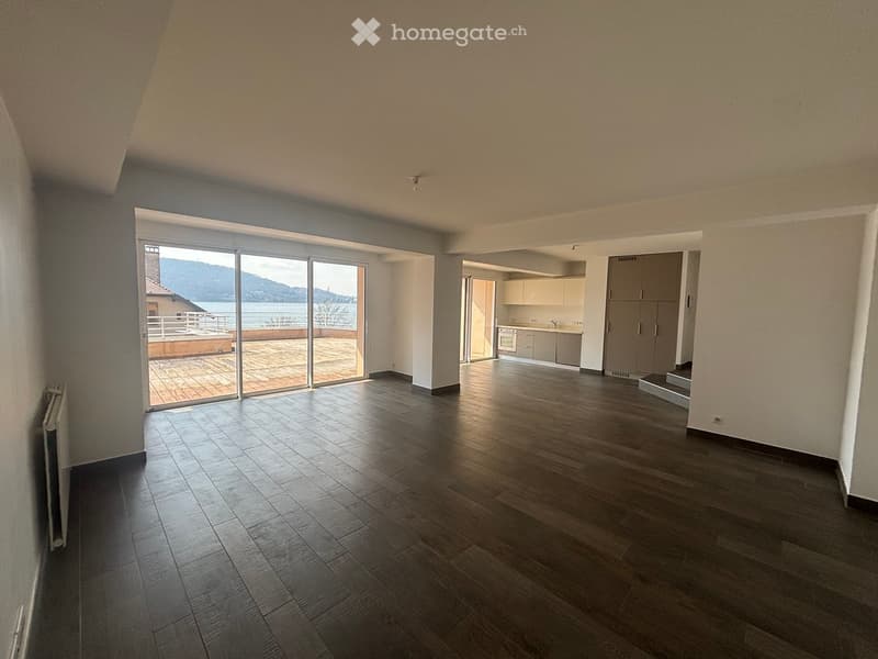 large open space, wooden floor, sliding glass doors, balcony, kitchen, cabinets, white walls