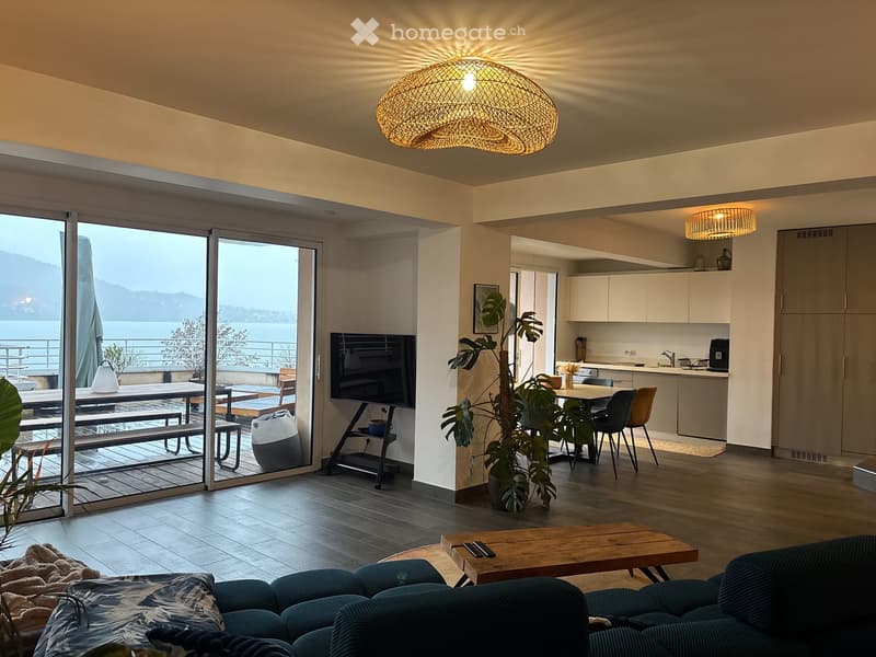 large windows, balcony, sliding glass doors, wooden floor, couch, coffee table, TV, plant