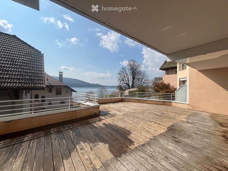 wooden deck, white railings, lake view, clear sky