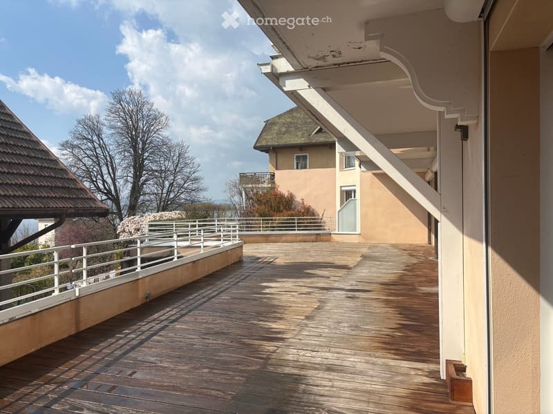 wooden floor, white railing, view of trees and houses