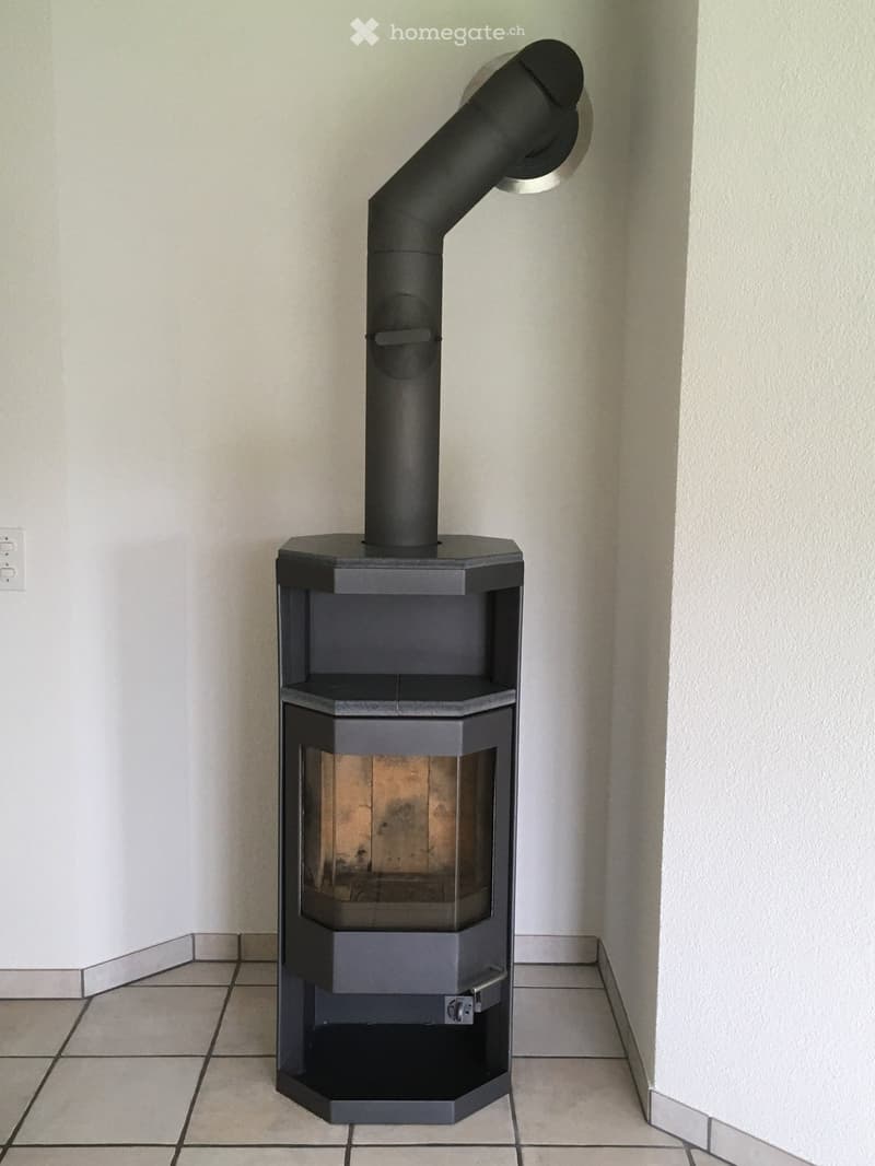 Fireplace in corner of room, white walls, tiled floor