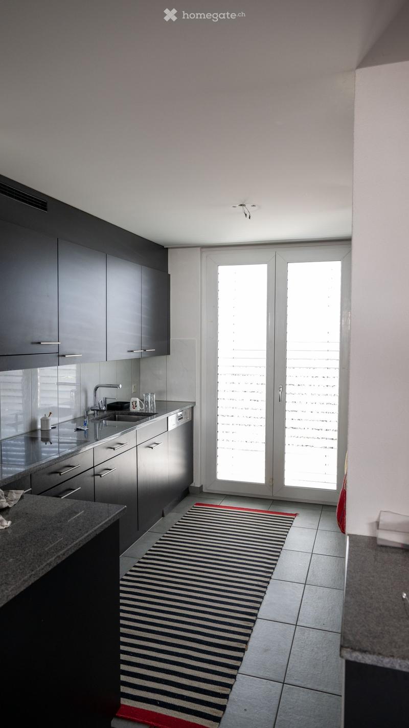 modern kitchen with black cabinets, granite countertops, stainless steel sink, dishwasher, washing machine, double doors leading to outside
