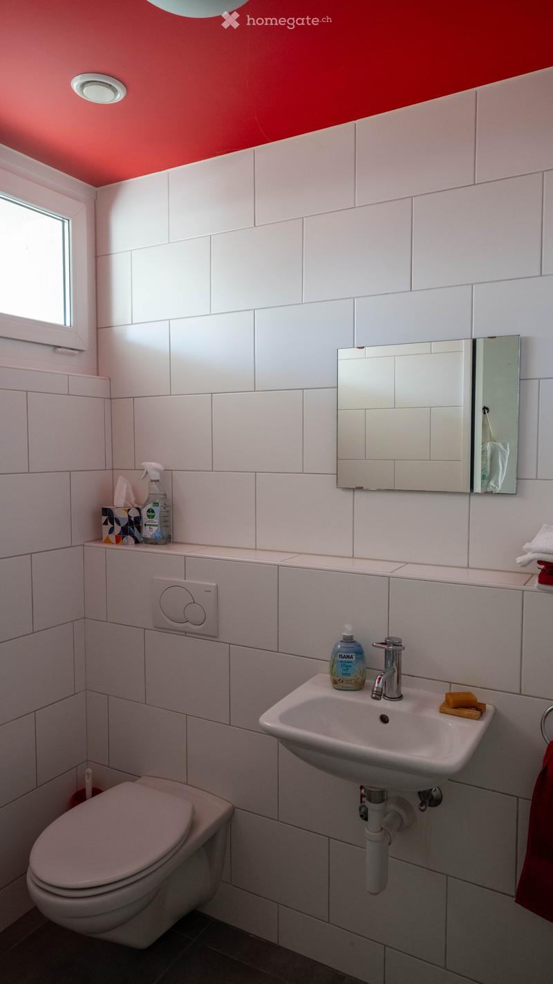 white tiled walls, white sink, white toilet, mirror, red ceiling, window