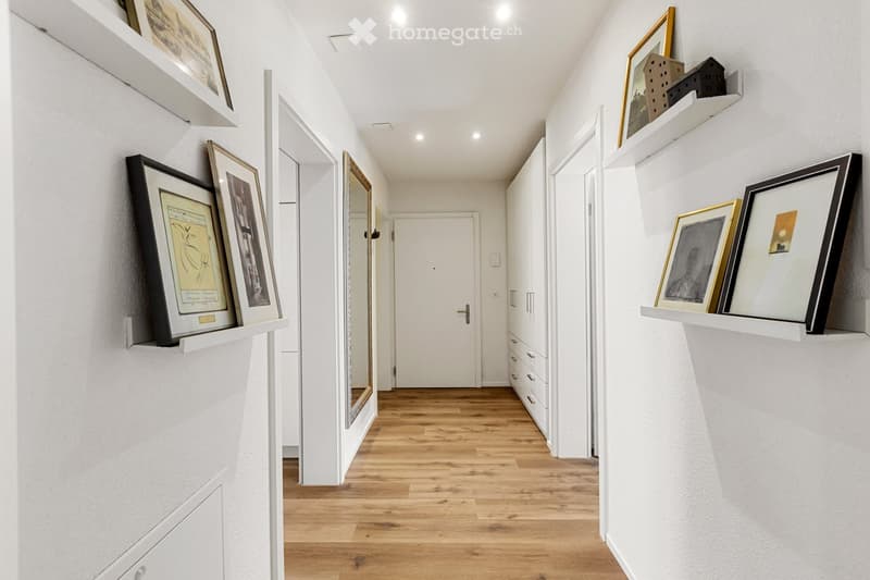 white walls, wooden floor, white door, white cabinets, picture frames on shelves