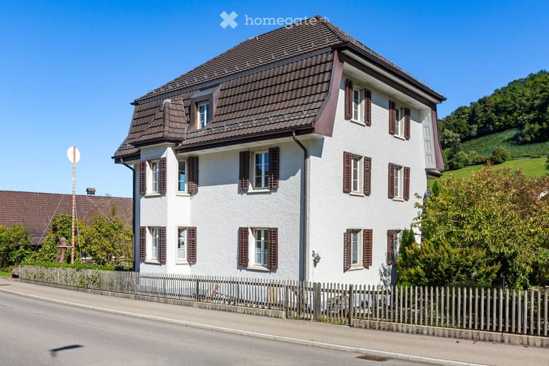 2 story house, white walls, brown roof, brown shutters, wooden fence, street