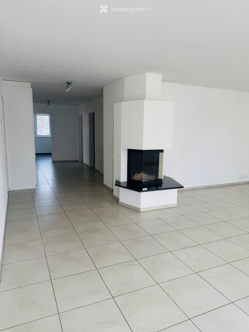 Empty room with fireplace, white walls, tiled floor, and ceiling lights