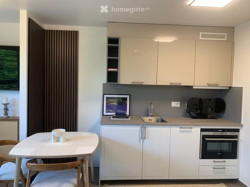 modern kitchen with white cabinets, granite countertop, sink, oven, dining table with chairs