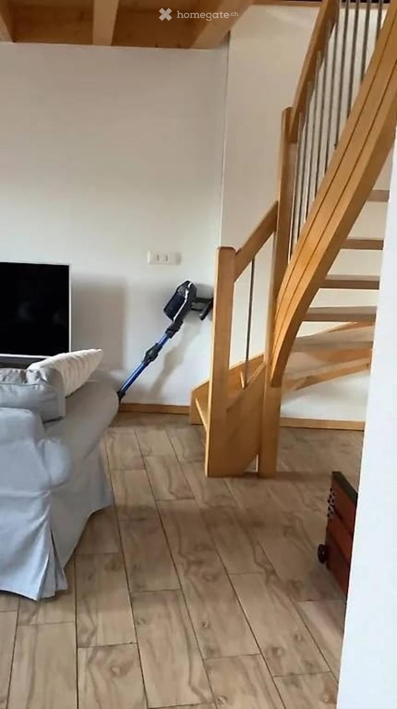 living room with couch, TV, wooden stairs, wooden floor