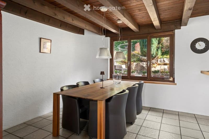Dining room with wooden table, black chairs, wooden ceiling, large window with view