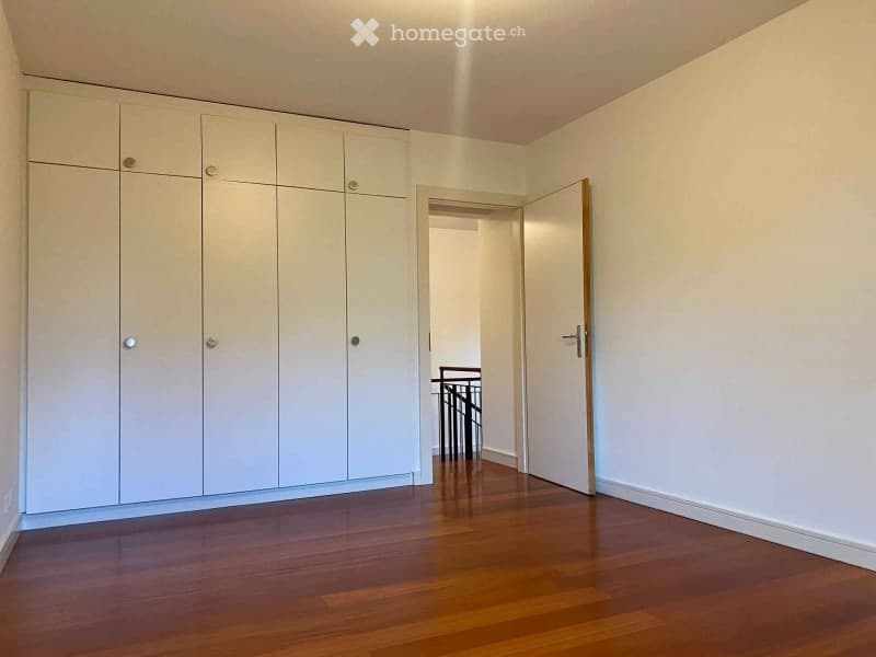 empty room, wooden floor, white walls, large white cabinets, open door