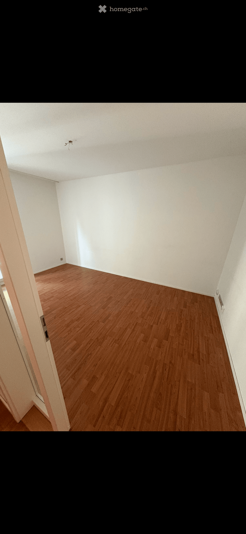 empty room, wooden floor, white walls, power outlet, door