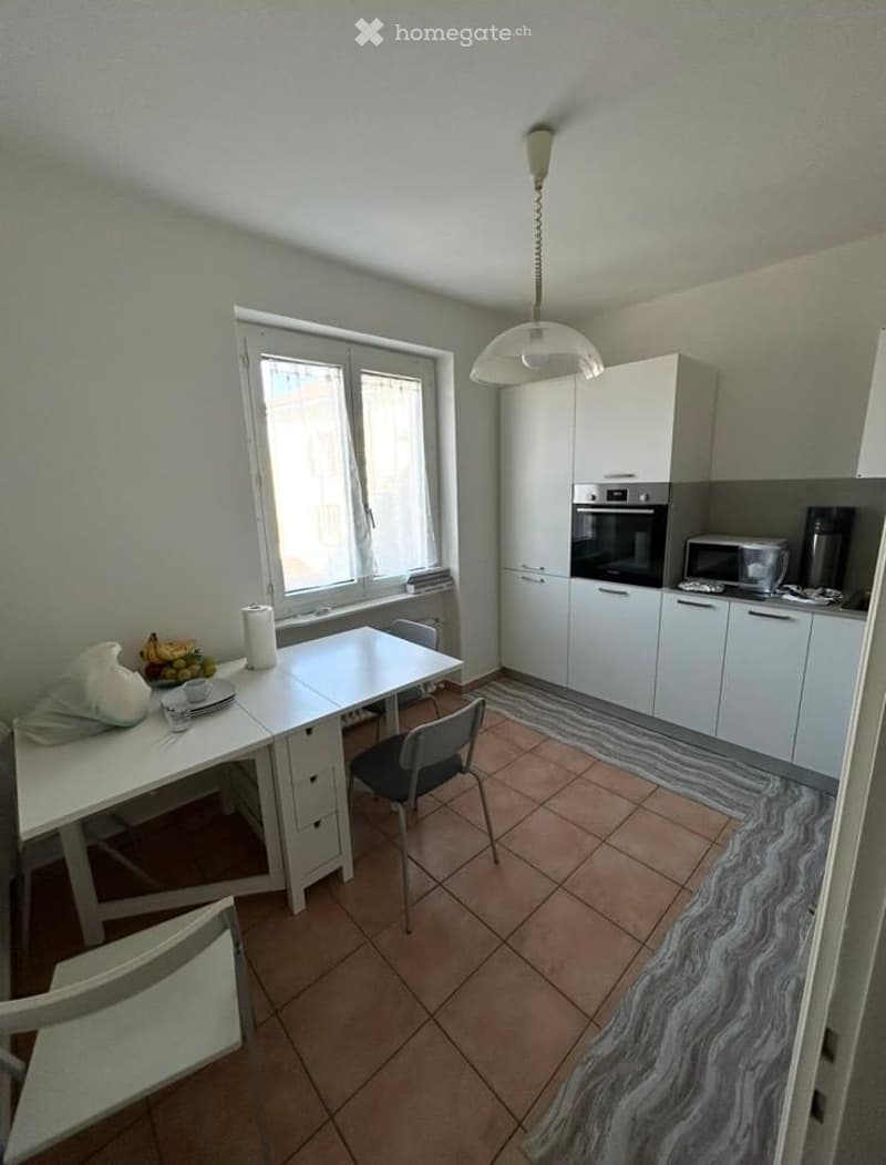 modern kitchen with white cabinets, tiled floor, dining table, chairs, oven, microwave, coffee machine, window with curtains