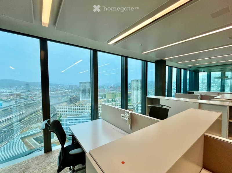 modern office space with large windows, city view, white desks, black chairs, white walls, ceiling lights