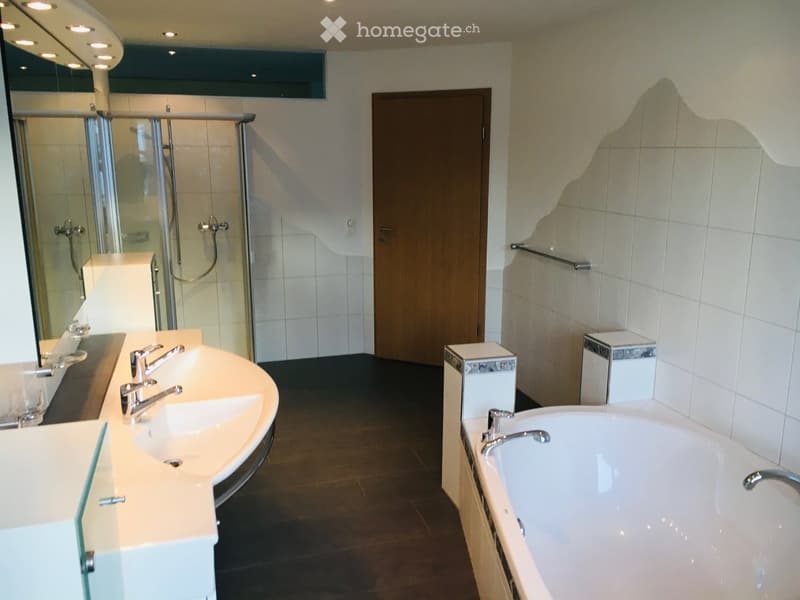 modern bathroom with bathtub, double sink, shower, and wooden door