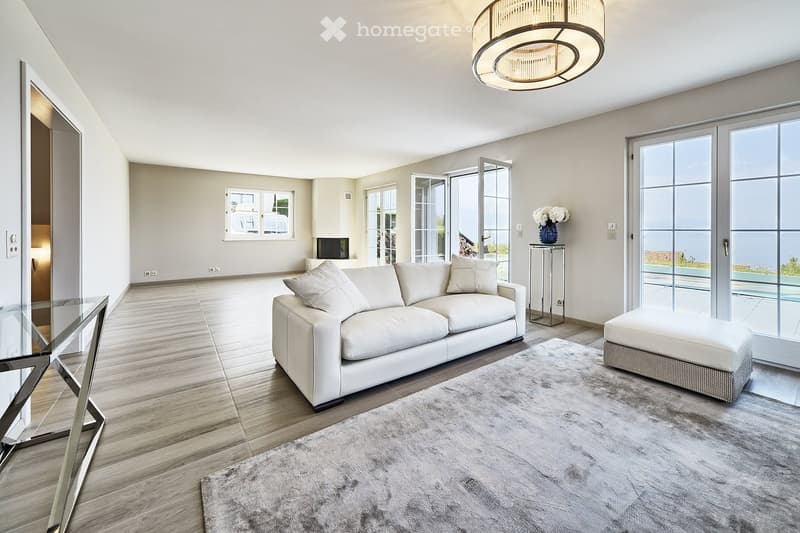 modern living room with white leather couch, glass table, carpet, sliding glass doors, balcony
