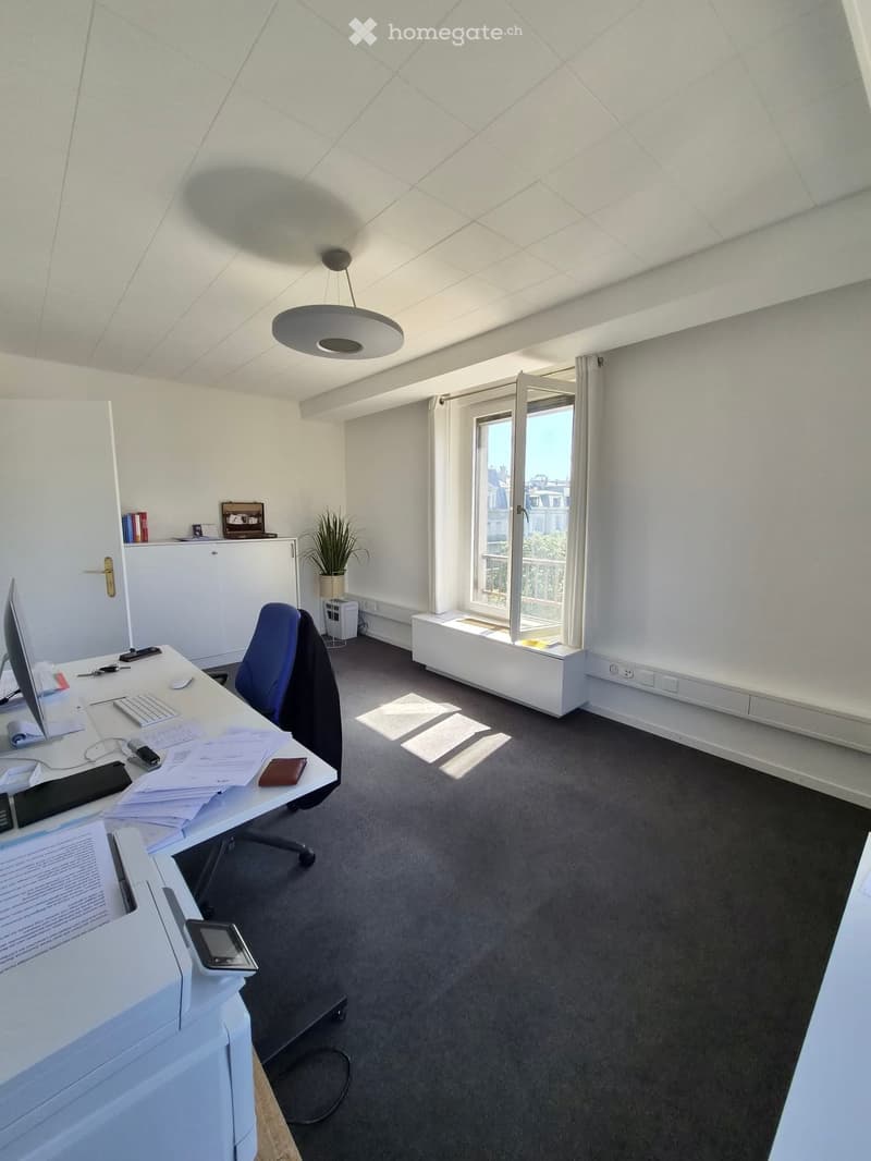 Office space with a desk, chair, computer, printer, and a window with a view.