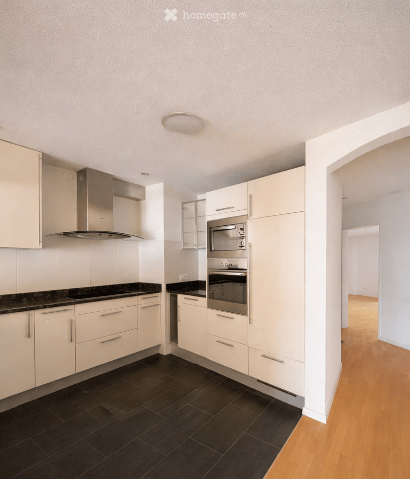 modern kitchen with white cabinets, black tiled floor, stainless steel appliances, wooden floor