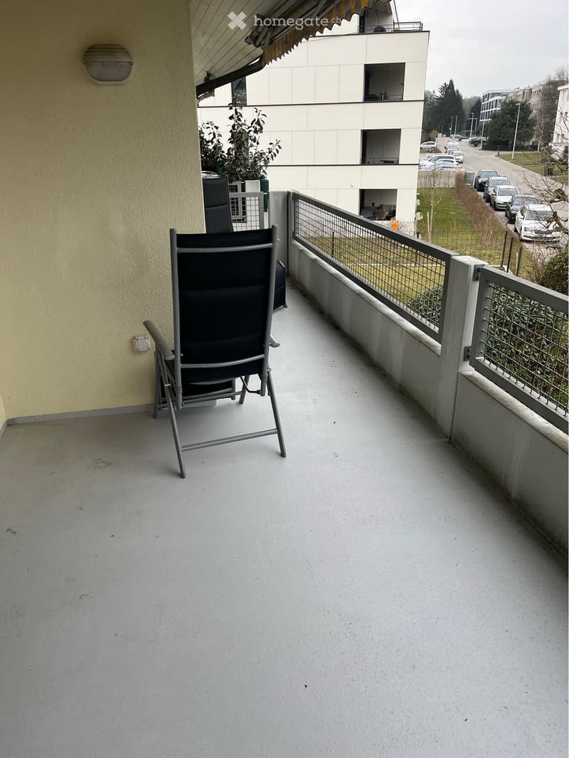 Balcony with two chairs, metal railing, yellow wall, outdoor light