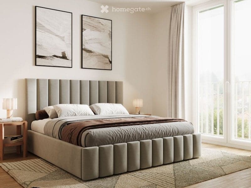 A bedroom with a large bed, a rug, a nightstand with a lamp, and a large window with a view of the outside.