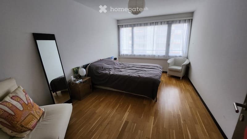 Bedroom with bed, mirror, nightstand, chair, lamp, and pillow