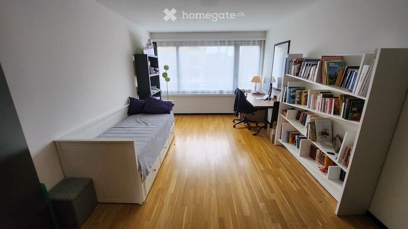 small bedroom with bed, desk, chair, bookshelf, window, lamp