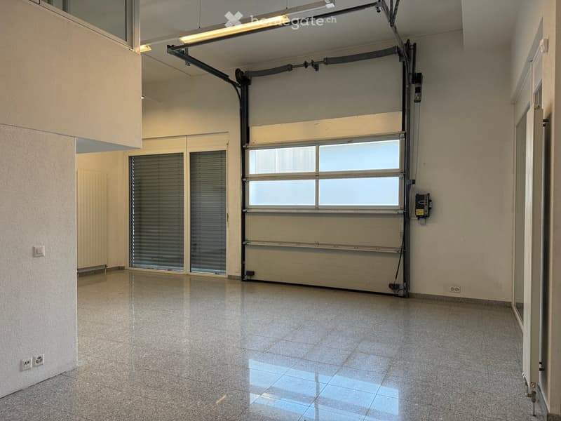 Empty room with a garage door, tiled floor, white walls, and a ceiling light