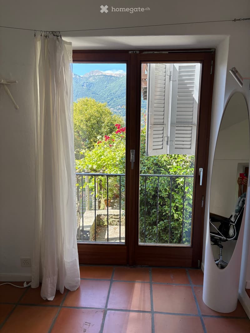 sliding glass door, balcony, white curtain, tiled floor, mirror, plants, mountains