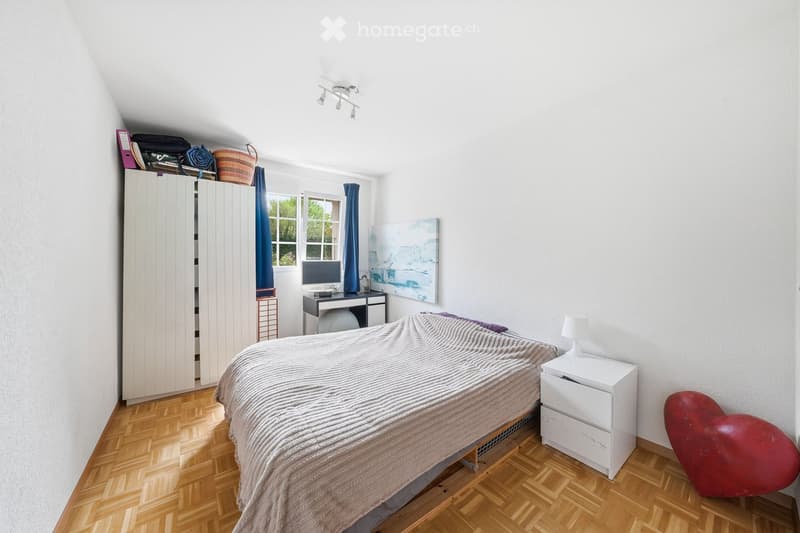 Bedroom with bed, desk, cabinet, and heart-shaped sculpture