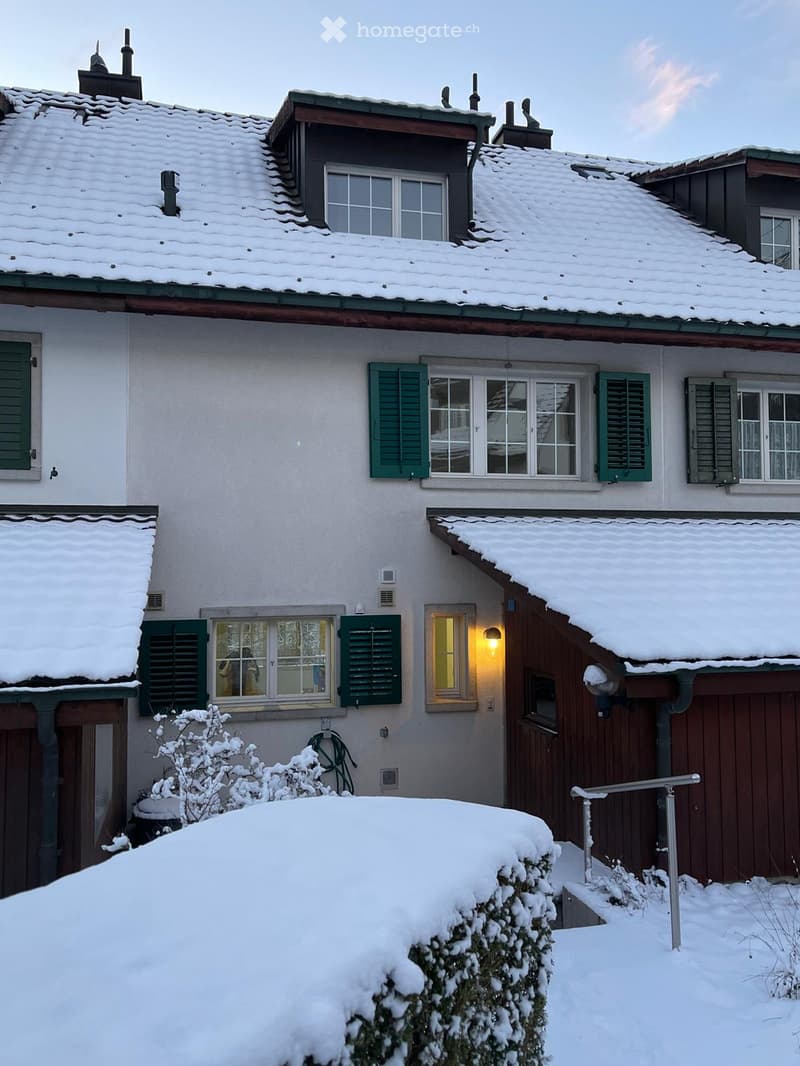 3-storey residential building, covered in snow, white facade, green shutters, brick walls, covered entrance
