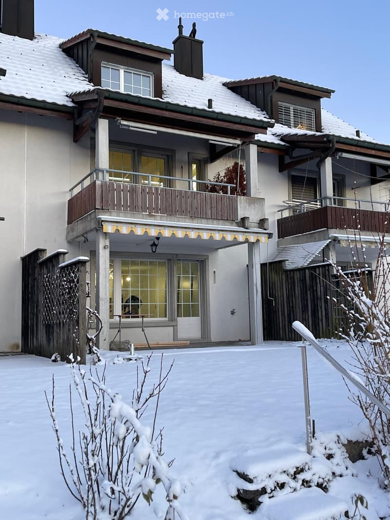 2 story house, white walls, balconies, awnings, snow-covered ground