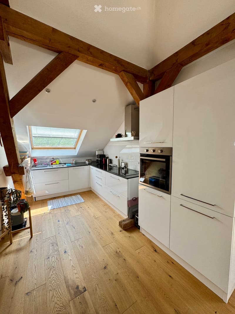 modern kitchen with wooden beams, white cabinets, wooden floor, oven, sink, window