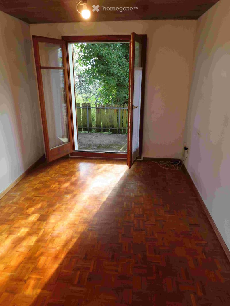 empty room, wooden floor, open door to balcony, white walls, ceiling light