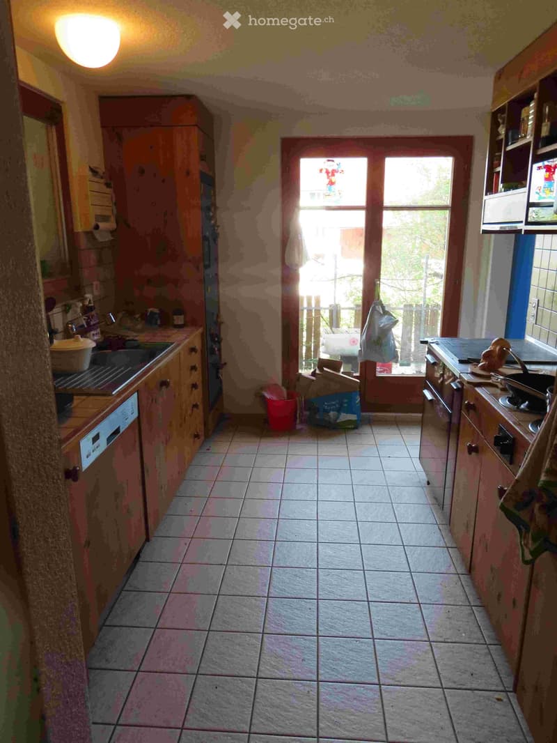 kitchen with wooden cabinets, tiled floor, sink, dishwasher, window, door