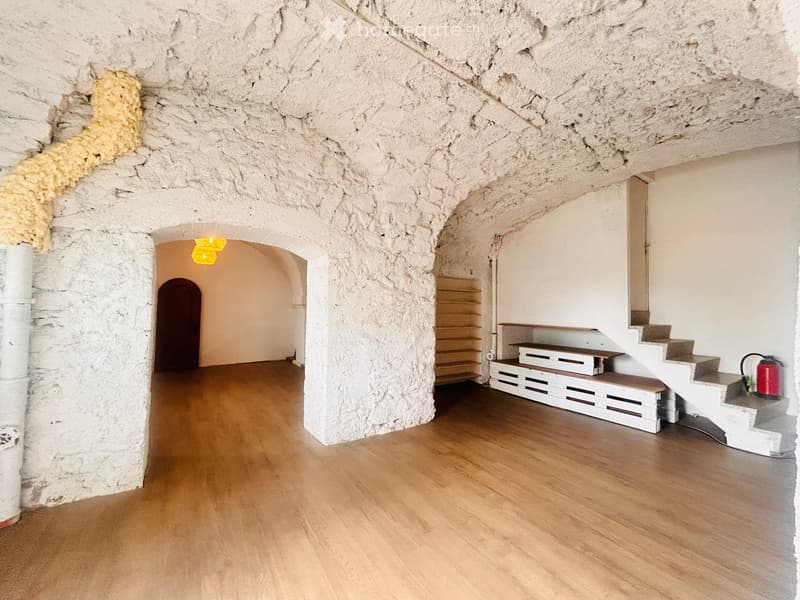 Concrete wall, wooden floor, small room in corner, stairs, storage drawers