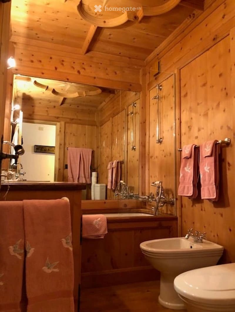 Bathroom with wooden walls, bathtub, sink, bidet, and toilet