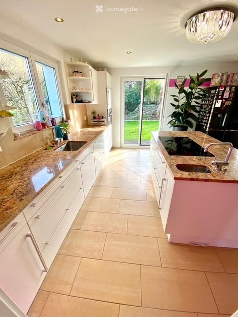 modern kitchen with granite countertops, white cabinets, double sinks, large windows, sliding glass door to garden