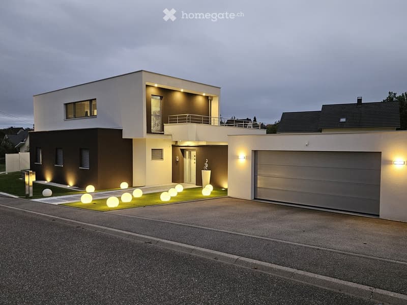 modern house, two garages, illuminated pathway, balcony, well-lit exterior