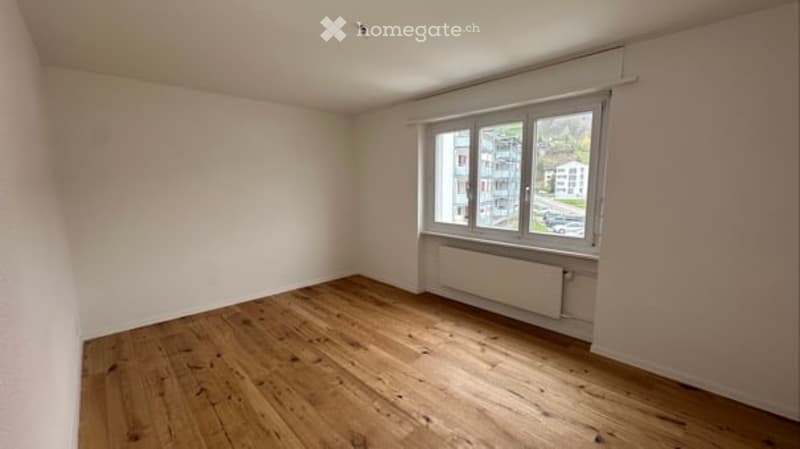 empty room, wooden floor, white walls, large window, radiator
