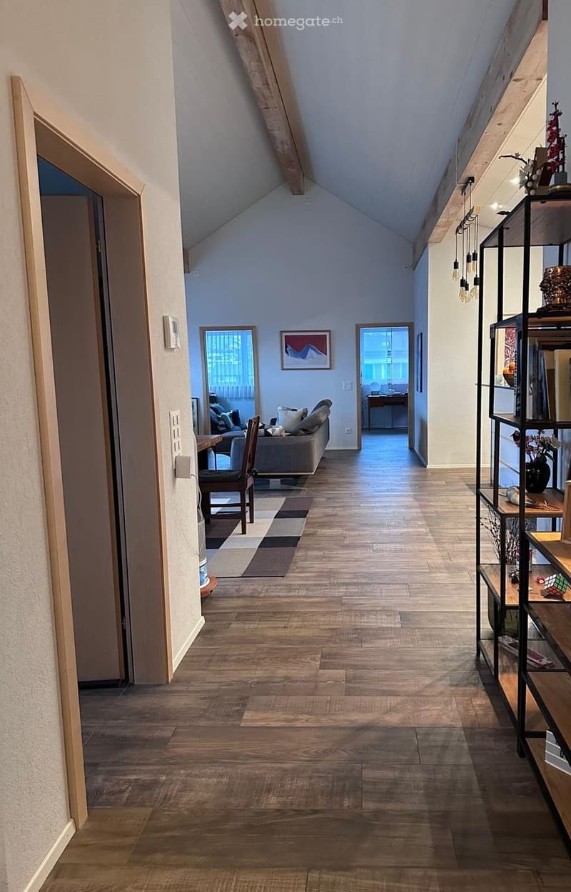 wooden floor, white walls, wooden beams, living room with sofa and coffee table, hallway, wooden chair, rug, shelves, picture frames, table with flowers