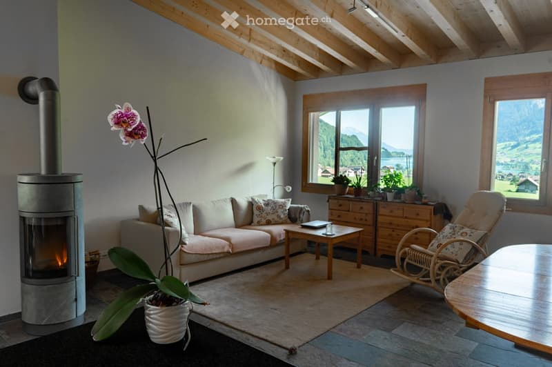 living room with sofa, coffee table, armchair, table, floor heater, windows with a view
