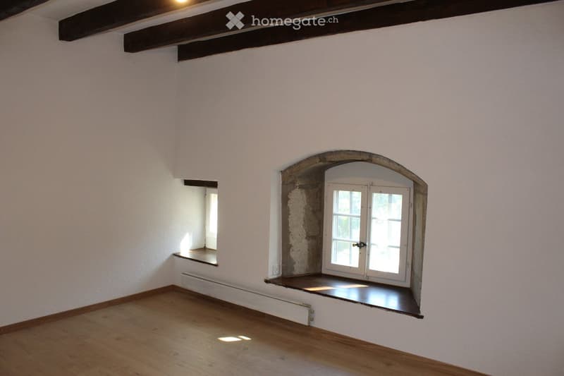 empty room, wooden floor, white walls, arched window, wooden beams