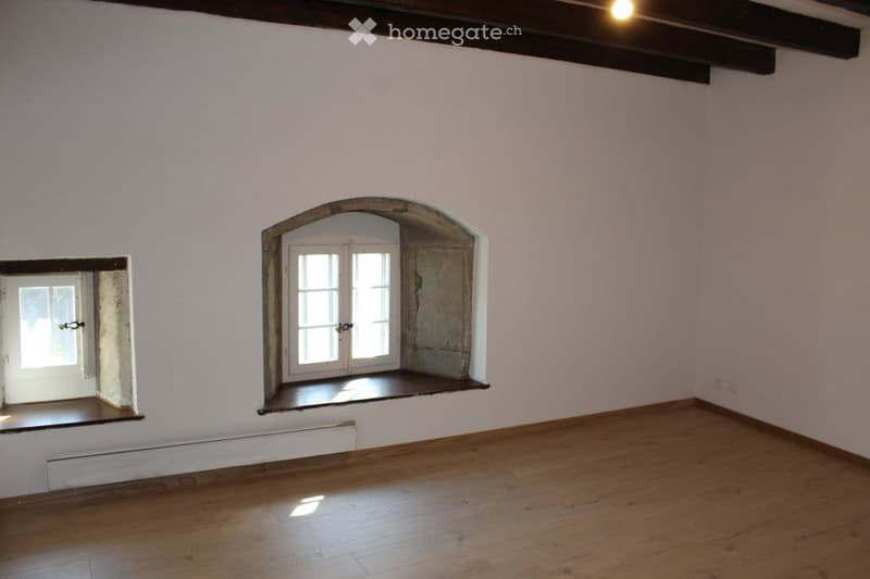 empty room, wooden floor, white walls, arched window, small window, wooden beams