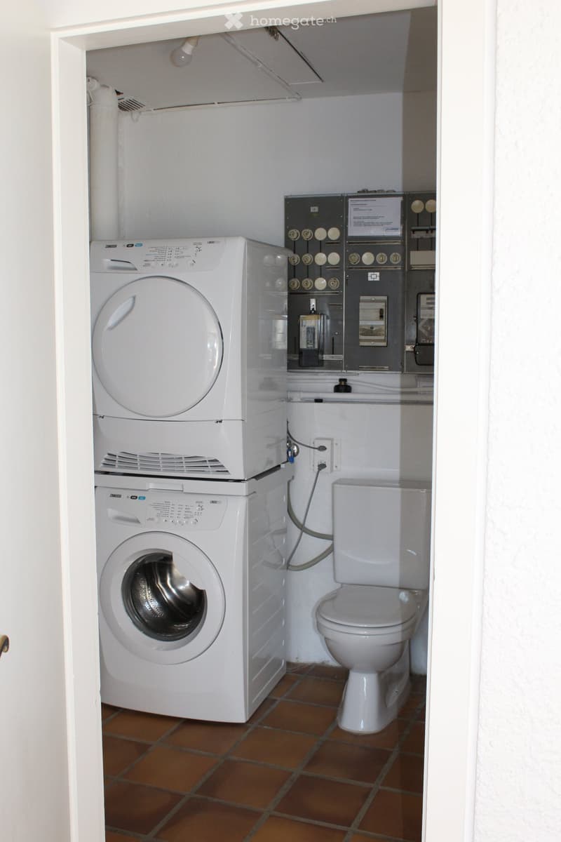 Small room with a washing machine, dryer, and toilet