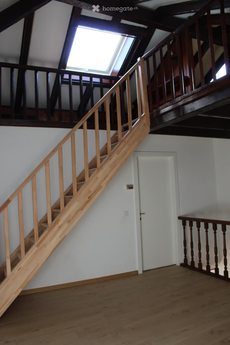 wooden stairs, wooden railings, white walls, wooden floor, white door