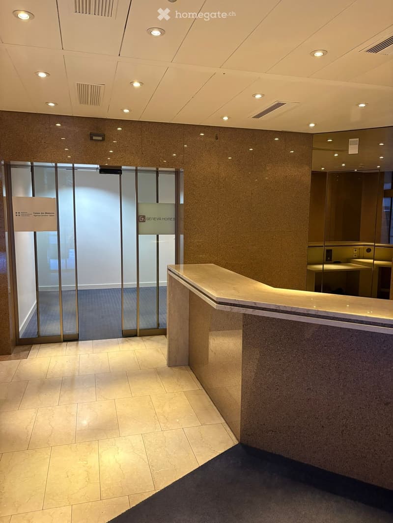 Reception area with marble counter, tiled floor, glass doors, and a sign